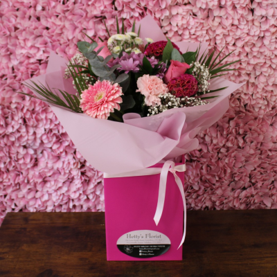 Petal Paradise - A lively bouquet featuring a bright mix of vibrant seasonal blooms. Complemented by lush green foliage and presented in a beautiful packaging, this arrangement is perfect for adding a pop of colour to any occasion